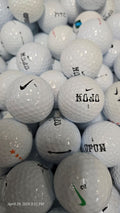 Stack of used golf balls with visible branding and wear.