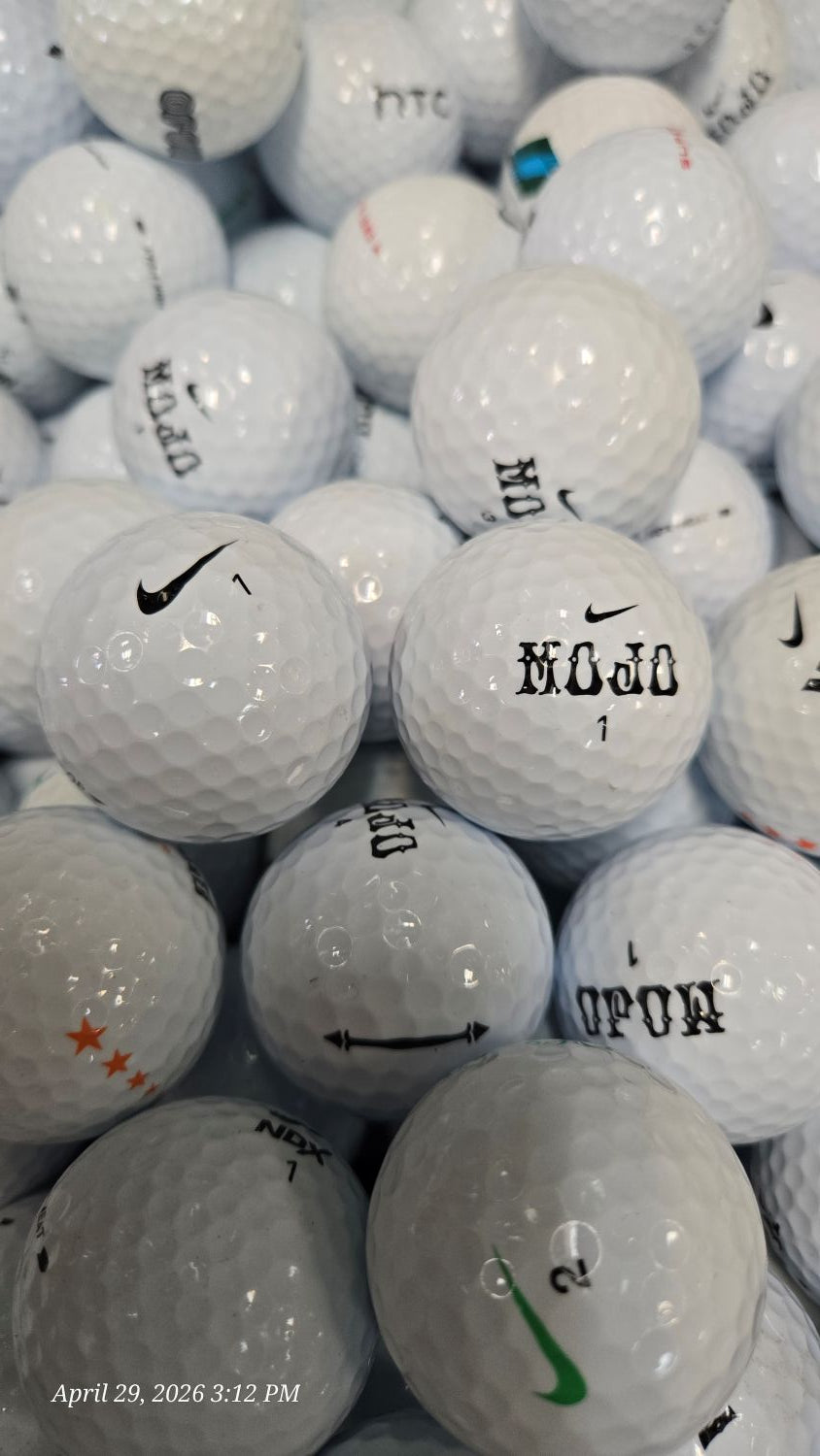 Stack of used golf balls with visible branding and wear.